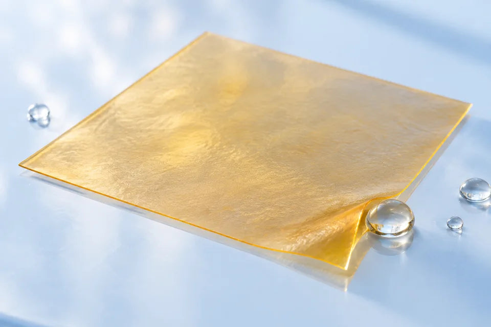 Illustration of a thin amber film touched by a drop of water on pale blue glass